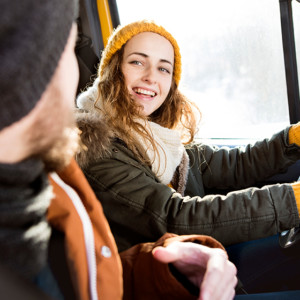 Beautiful young couple on a trip in winter, close up of girl driving.