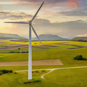 Aerial drone point of view of modern wind turbines in green rural landscape during a colorful sunset twilight. Green Energy, Alternative Energy Environment Concept Shot. Baden Württemberg, South Germany, Europe