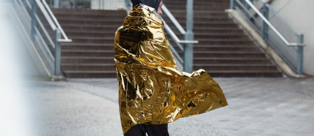 Person wrapped in gold and silver space blanket